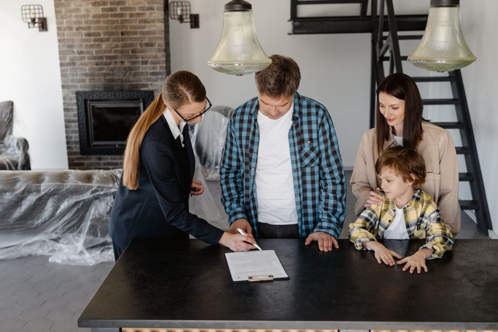 real estate agent showing a contract to a family.