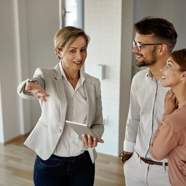 How to choose a real estate broker: complete guide 3 A man and woman stand together in an open house, discussing the property in a bright, spacious living area.