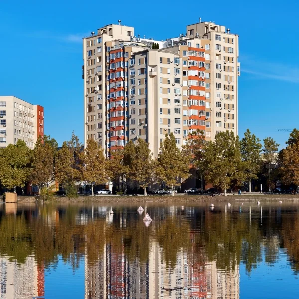 Buying a condo in Montreal: the essential steps 2 A serene lake with a building visible in the background under a clear blue sky.
